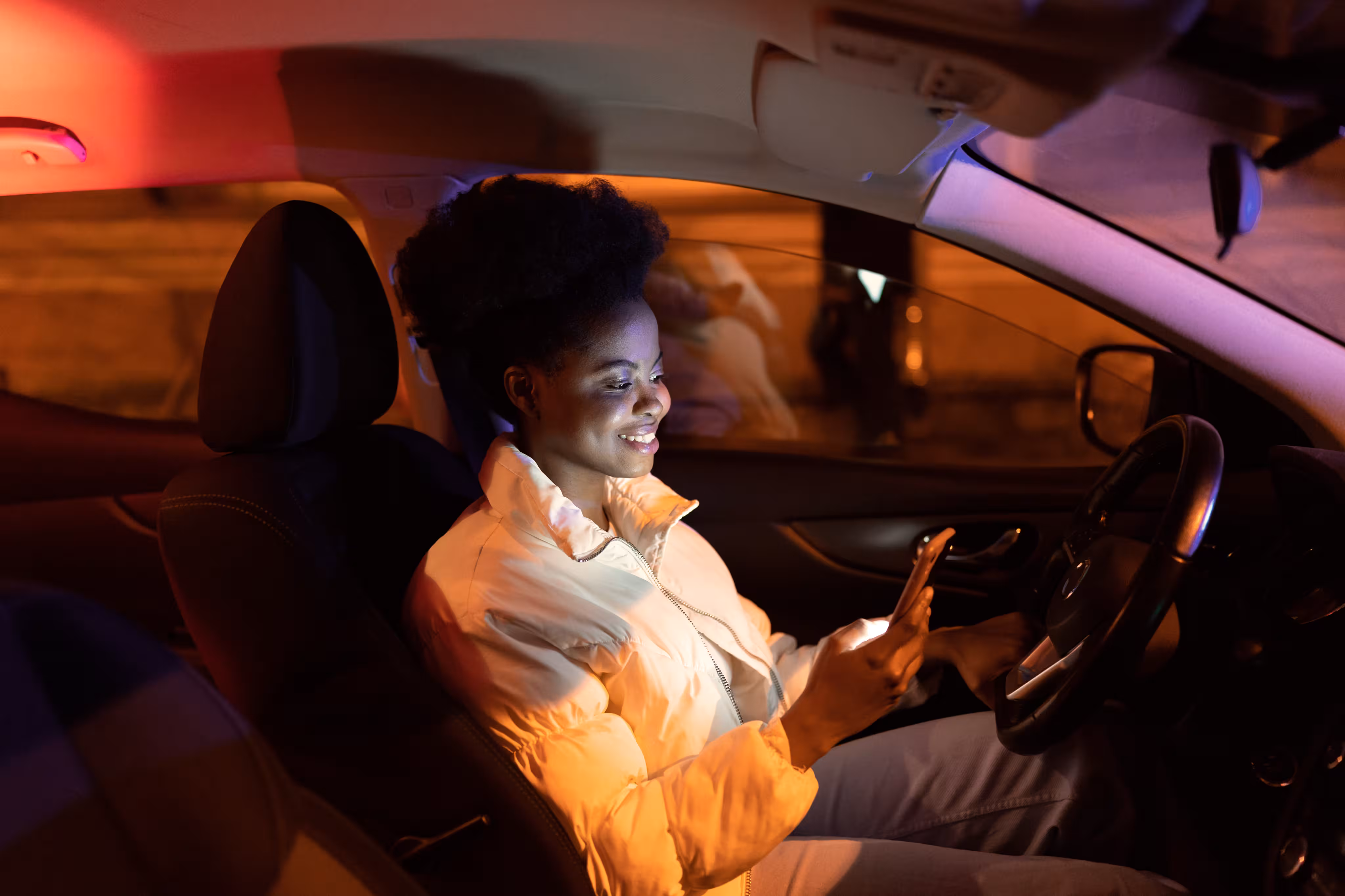 Person nutzt eine mobile App im Auto